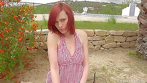Red-haired lady strips naked on grass and loves the breeze
